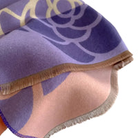 Close-up of a purple fabric with gold and white patterns on a white background