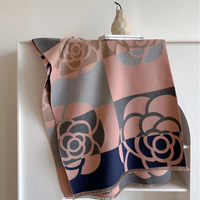 Floral patterned blanket draped over a white cabinet with a neutral background