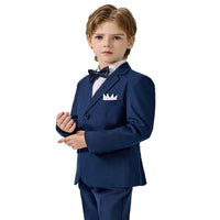 Young boy in a formal blue suit with bow tie on a plain background