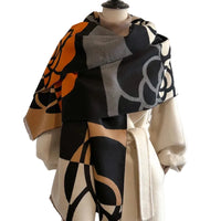 Mannequin wearing a patterned scarf and beige outfit against a plain background