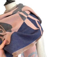 Scarf with geometric pattern draped over a mannequin against a neutral background