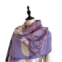Purple and beige patterned scarf on a mannequin against a plain background