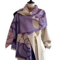 Mannequin wearing a beige coat with a purple patterned scarf draped over it against a white background.