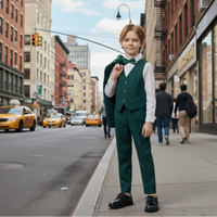The image of a young boy wearing a green suit with a white shirt and black shoes on a plain background.