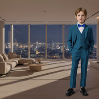 A view of a young boy wearing a blue suit with a bow tie on a plain background