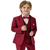 Young boy wearing a red suit with a white shirt and red bow tie on a light gray background